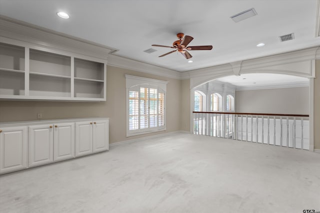 carpeted spare room with ceiling fan and crown molding