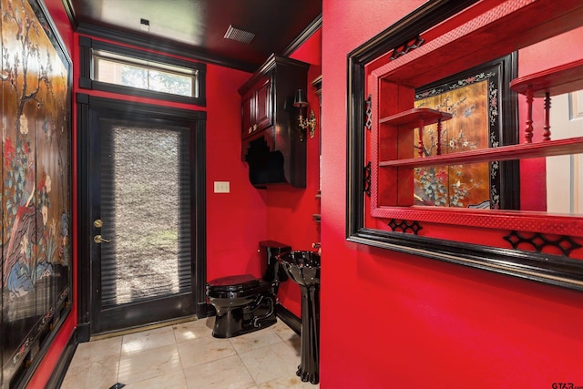 doorway featuring light tile patterned flooring and ornamental molding