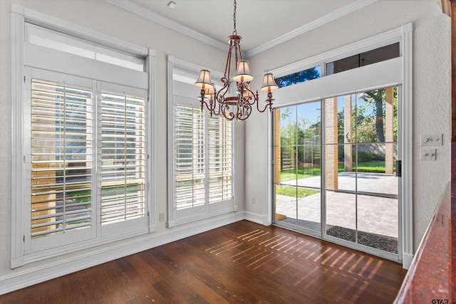 unfurnished dining area with dark hardwood / wood-style floors, crown molding, and a chandelier