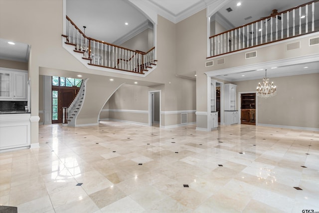 unfurnished living room with a notable chandelier, ornamental molding, and a high ceiling