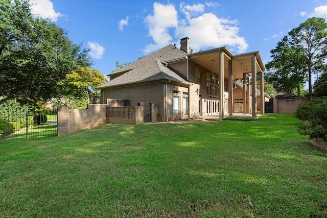 rear view of house featuring a lawn