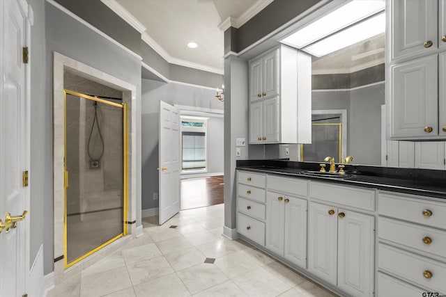 bathroom featuring tile patterned floors, vanity, crown molding, and a shower with shower door