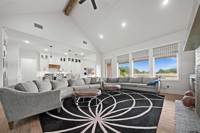 living room featuring ceiling fan, dark hardwood / wood-style floors, beam ceiling, high vaulted ceiling, and a fireplace