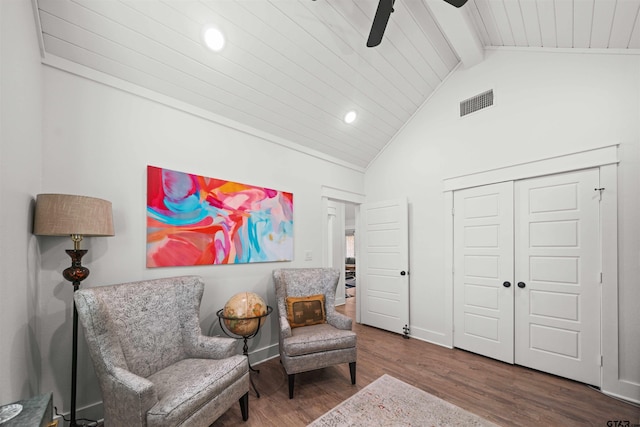 living area featuring high vaulted ceiling, hardwood / wood-style floors, ceiling fan, and beam ceiling