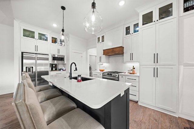 kitchen featuring appliances with stainless steel finishes, sink, a center island with sink, and white cabinets