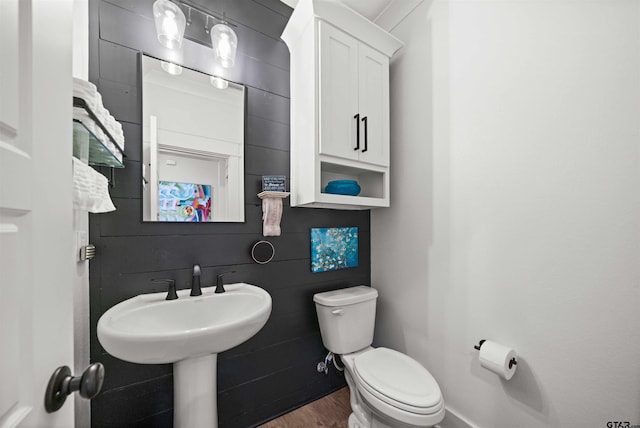 bathroom featuring tile walls, hardwood / wood-style floors, and toilet