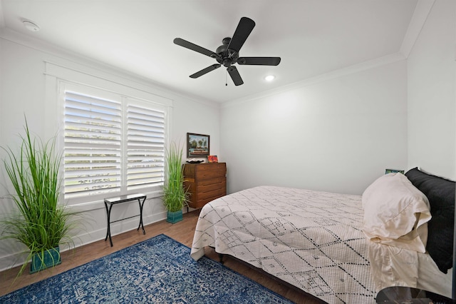 bedroom featuring hardwood / wood-style flooring, ceiling fan, and crown molding