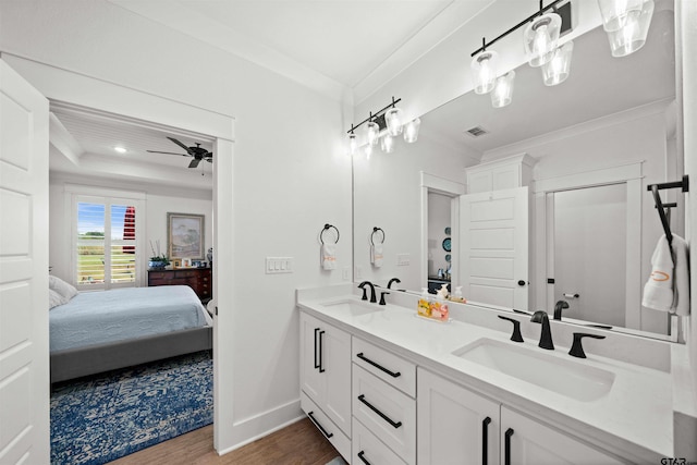 bathroom with ornamental molding, vanity, hardwood / wood-style flooring, and ceiling fan