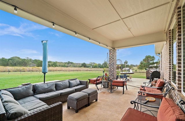 view of patio with an outdoor living space and a rural view