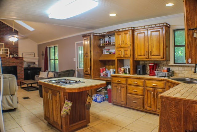 kitchen featuring tile counters, plenty of natural light, sink, and a center island