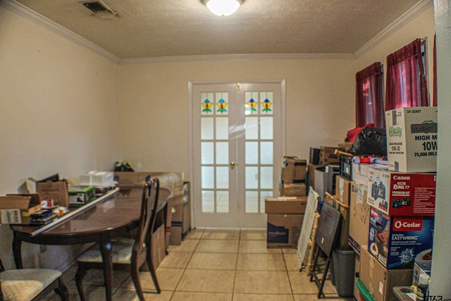 tiled dining room featuring a textured ceiling, french doors, and ornamental molding