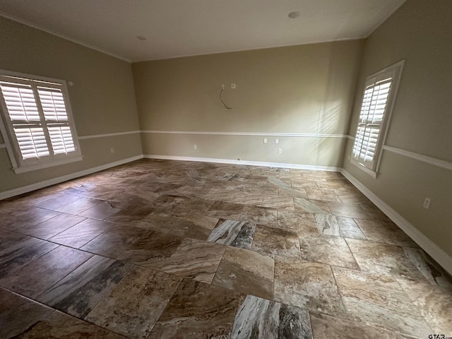 empty room featuring crown molding and plenty of natural light