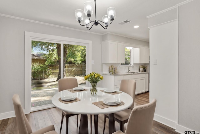 dining room with sink, crown molding, and dark wood-type flooring