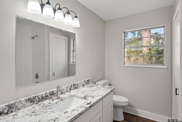 bathroom featuring vanity, hardwood / wood-style floors, a notable chandelier, and toilet