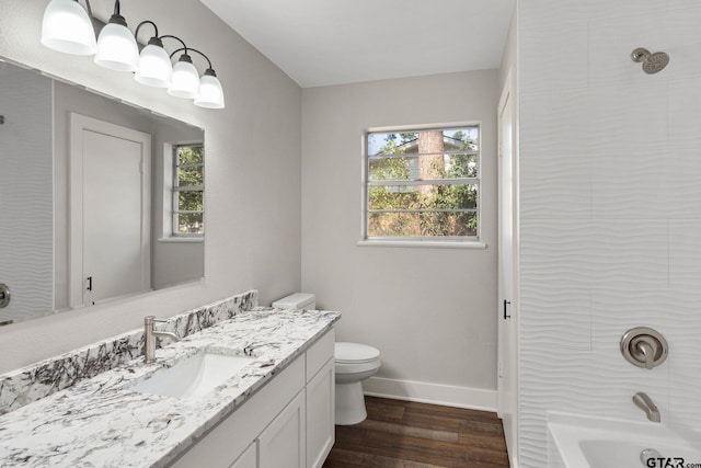 full bathroom featuring wood-type flooring, vanity, shower / bathtub combination, and toilet