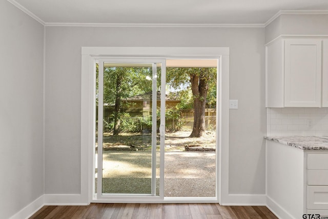 doorway to outside featuring wood-type flooring and ornamental molding