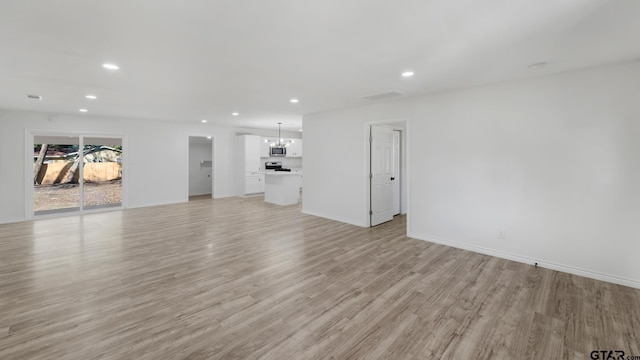 unfurnished living room featuring light hardwood / wood-style floors and a notable chandelier