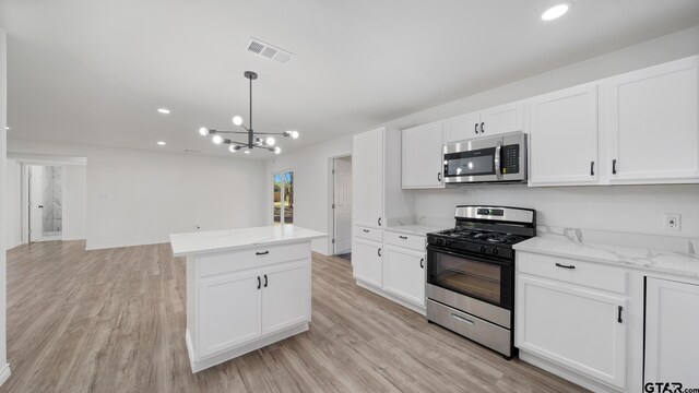 kitchen featuring white cabinetry, light hardwood / wood-style floors, a notable chandelier, and appliances with stainless steel finishes