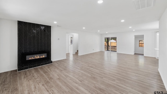 unfurnished living room featuring light hardwood / wood-style floors and a fireplace