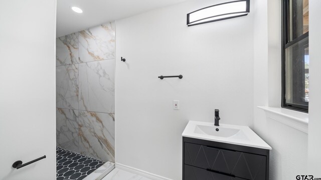 bathroom featuring a tile shower and vanity