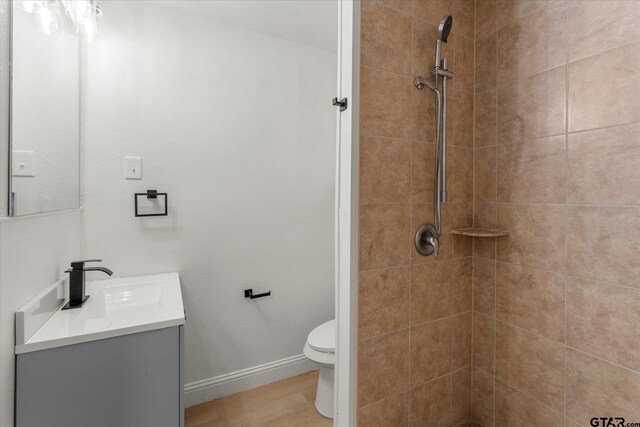 2002 Friendly Ave, Mount Pleasant, TX 75455 - bathroom with vanity, tiled shower, and toilet