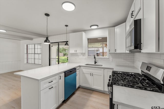 2002 Friendly Ave, Mount Pleasant, TX 75455 - kitchen with appliances with stainless steel finishes, a sink, a peninsula, tasteful backsplash, and light wood-type flooring