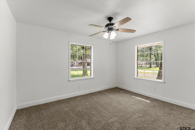 2002 Friendly Ave, Mount Pleasant, TX 75455 - spare room featuring carpet floors, a ceiling fan, and baseboards