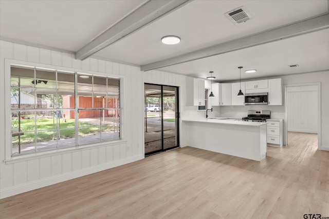 2002 Friendly Ave, Mount Pleasant, TX 75455 - kitchen with stainless steel appliances, beamed ceiling, light wood-type flooring, a peninsula, and a sink