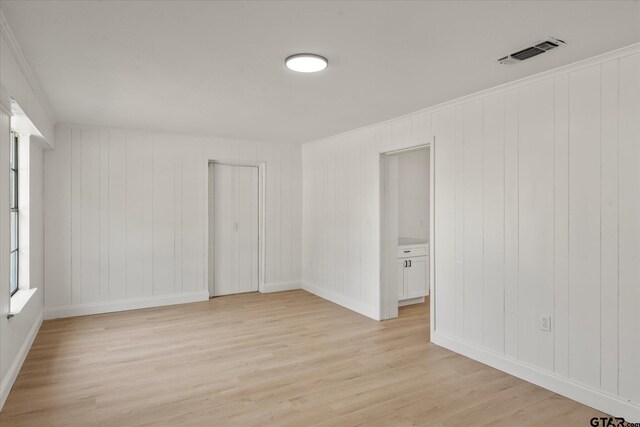 2002 Friendly Ave, Mount Pleasant, TX 75455 - spare room featuring light wood-type flooring, baseboards, and ornamental molding