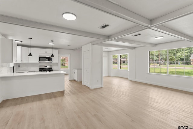 2002 Friendly Ave, Mount Pleasant, TX 75455 - kitchen with appliances with stainless steel finishes, a sink, open floor plan, light wood-type flooring, and baseboards