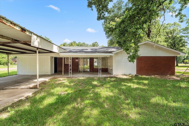 2002 Friendly Ave, Mount Pleasant, TX 75455 - back of property featuring an attached carport, a lawn, and brick siding