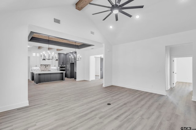 unfurnished living room with light hardwood / wood-style floors, high vaulted ceiling, beamed ceiling, and ceiling fan with notable chandelier