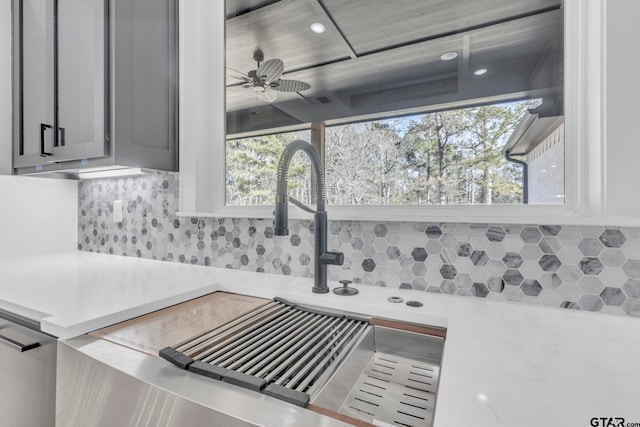 kitchen with ceiling fan, gray cabinetry, tasteful backsplash, and sink