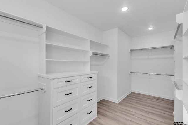 walk in closet with light hardwood / wood-style flooring