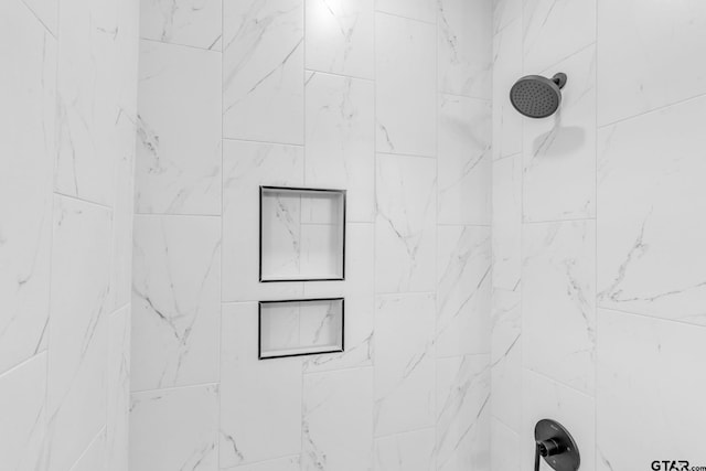 interior details featuring tiled shower