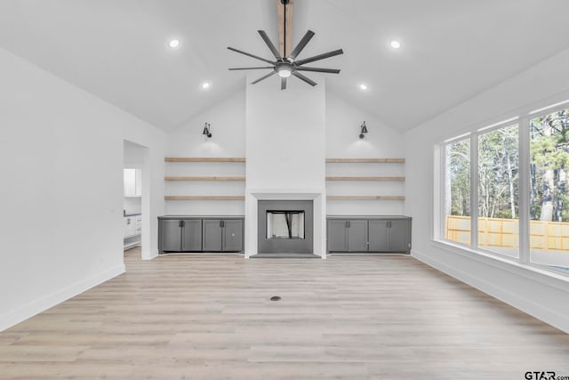 unfurnished living room with high vaulted ceiling, ceiling fan, and light hardwood / wood-style floors