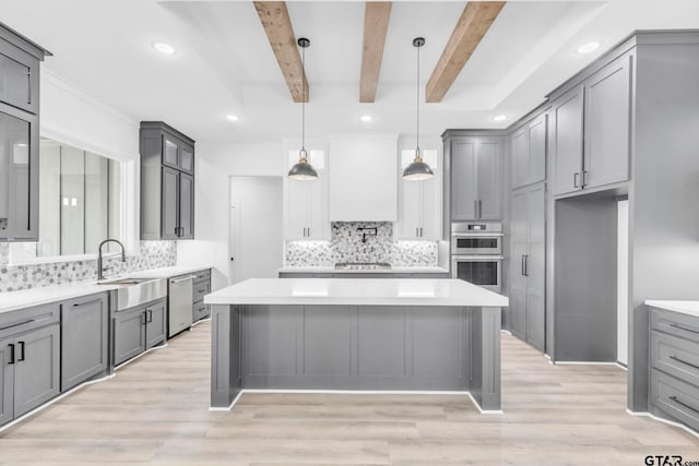 kitchen with a center island, decorative light fixtures, stainless steel appliances, beamed ceiling, and gray cabinetry