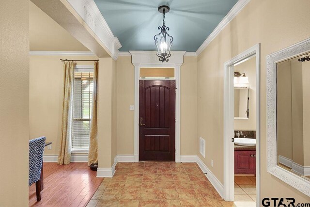 803 Marquette Ln, Tyler, TX 75703 - entrance foyer featuring baseboards, ornamental molding, and a chandelier