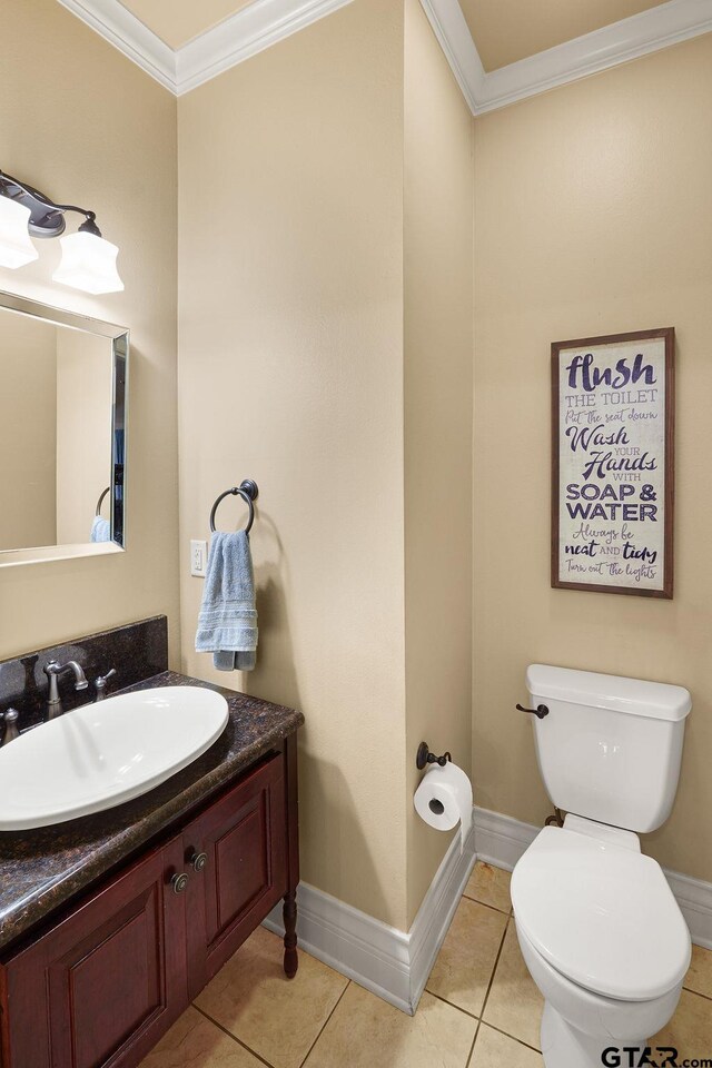 803 Marquette Ln, Tyler, TX 75703 - bathroom with ornamental molding, toilet, vanity, tile patterned flooring, and baseboards