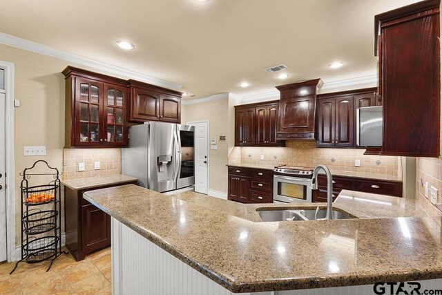 803 Marquette Ln, Tyler, TX 75703 - kitchen with stainless steel appliances, a sink, under cabinet range hood, backsplash, and ornamental molding