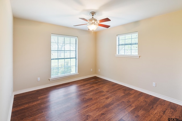 empty room with ceiling fan, dark hardwood / wood-style floors, and plenty of natural light