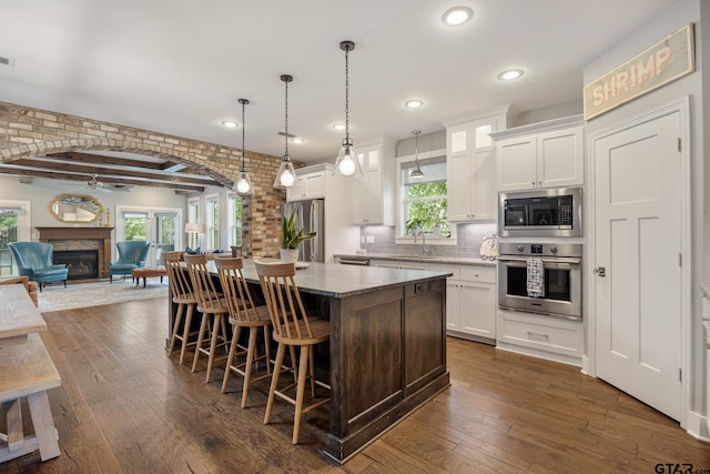 759 Hampton Hill Hill, Tyler, TX 75703 - kitchen with appliances with stainless steel finishes, a kitchen island, a breakfast bar, open floor plan, and white cabinets