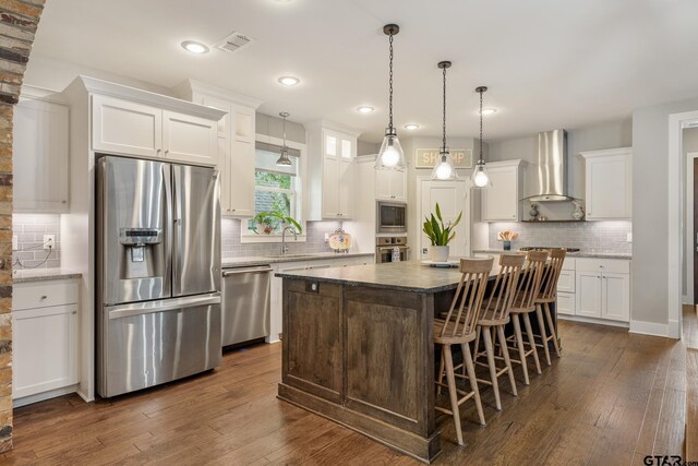 759 Hampton Hill Hill, Tyler, TX 75703 - kitchen with stainless steel appliances, wall chimney exhaust hood, a kitchen island, backsplash, and recessed lighting