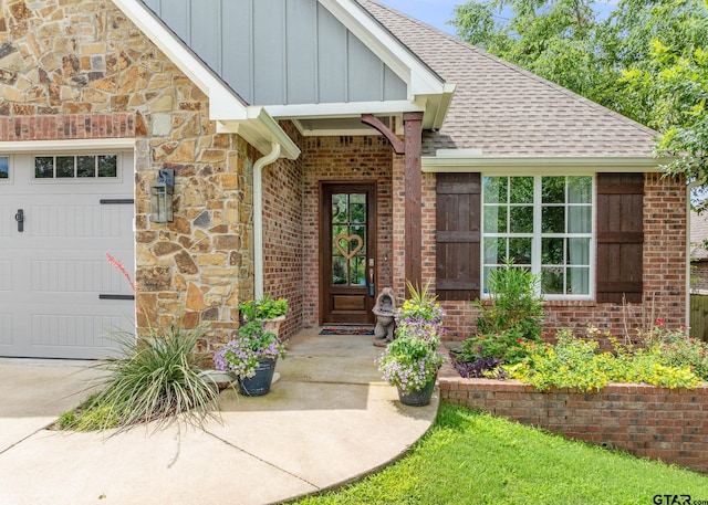 759 Hampton Hill Hill, Tyler, TX 75703 - view of exterior entry with roof with shingles, stone siding, board and batten siding, an attached garage, and brick siding
