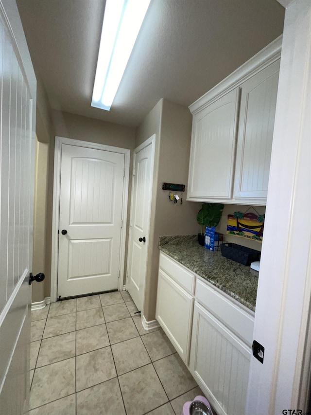 214 Rosebrook Cir, Whitehouse, TX 75791 - kitchen featuring white cabinets, light tile patterned floors, and light stone countertops