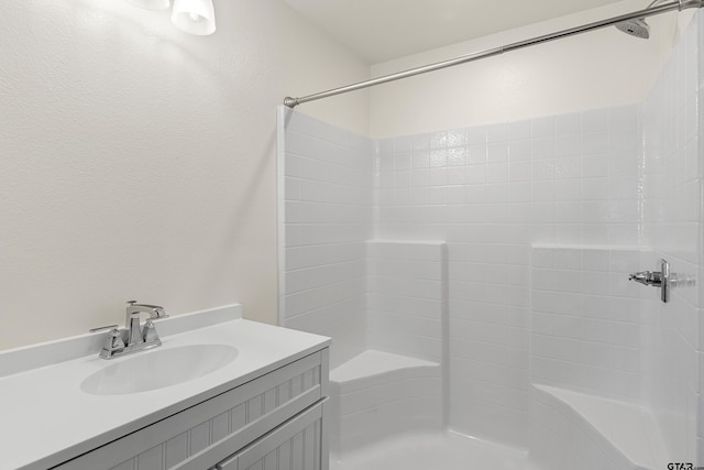 bathroom featuring walk in shower and vanity