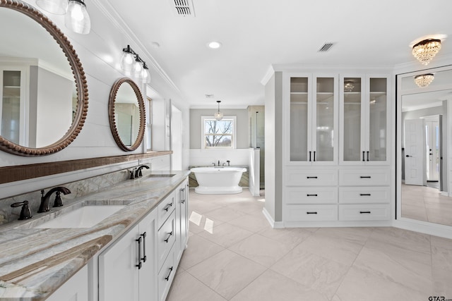 bathroom featuring a washtub, vanity, and crown molding