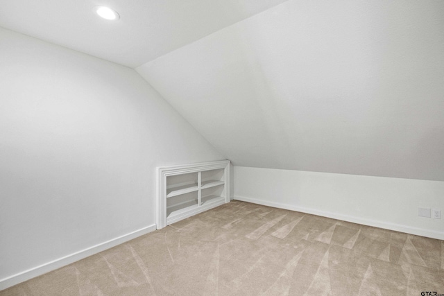 bonus room featuring lofted ceiling and light carpet