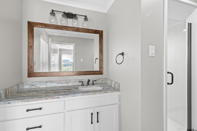 bathroom featuring ornamental molding, vanity, and a shower with shower door