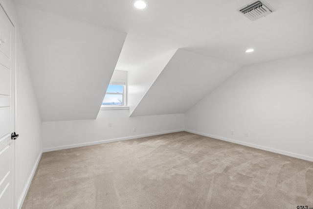 bonus room featuring lofted ceiling and light carpet